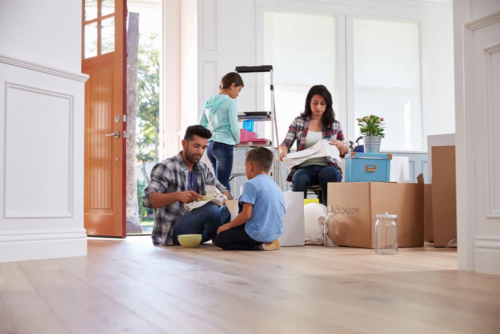 People unpacking moving boxes in a new home